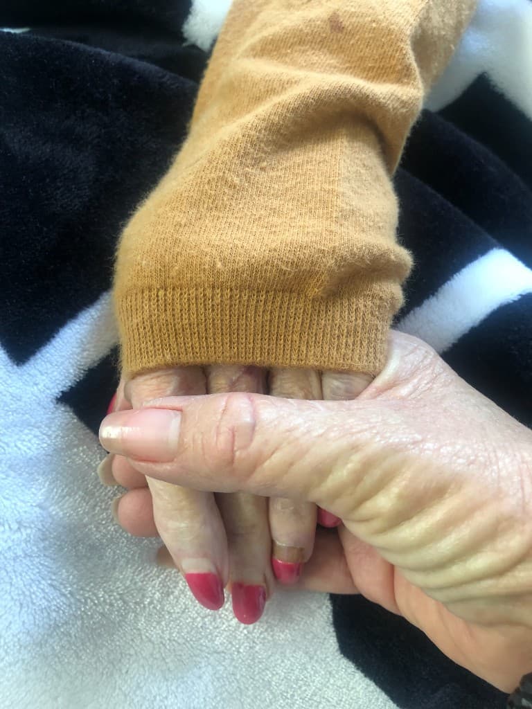 Caregiver holding an older adult's hand