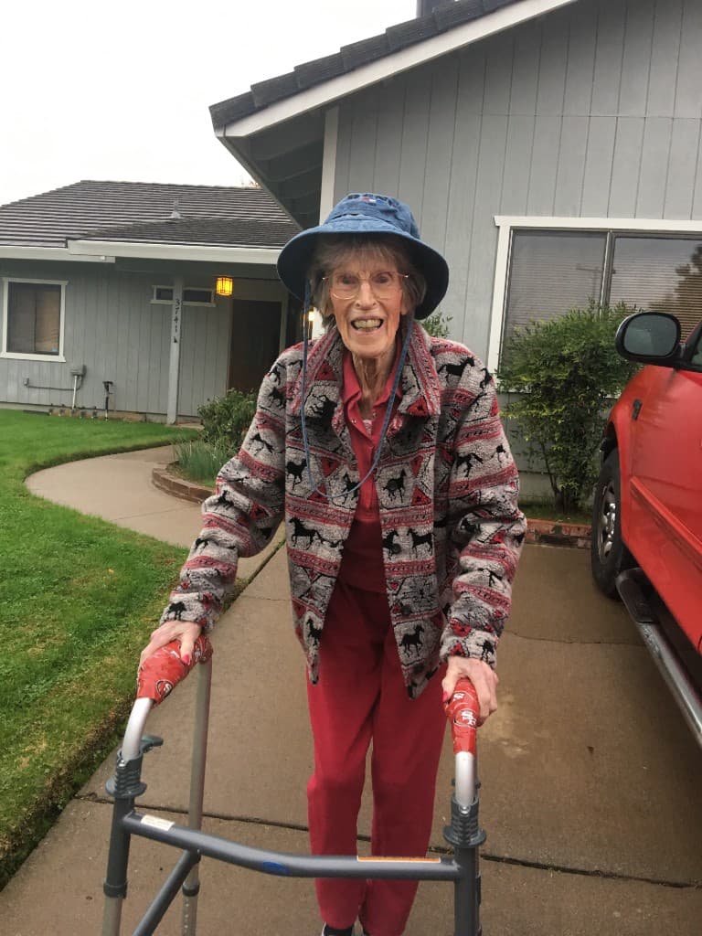 Older adult using a walker near home
