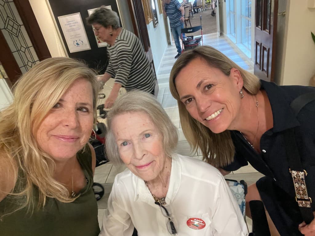 Three seniors outside with a friendly wave